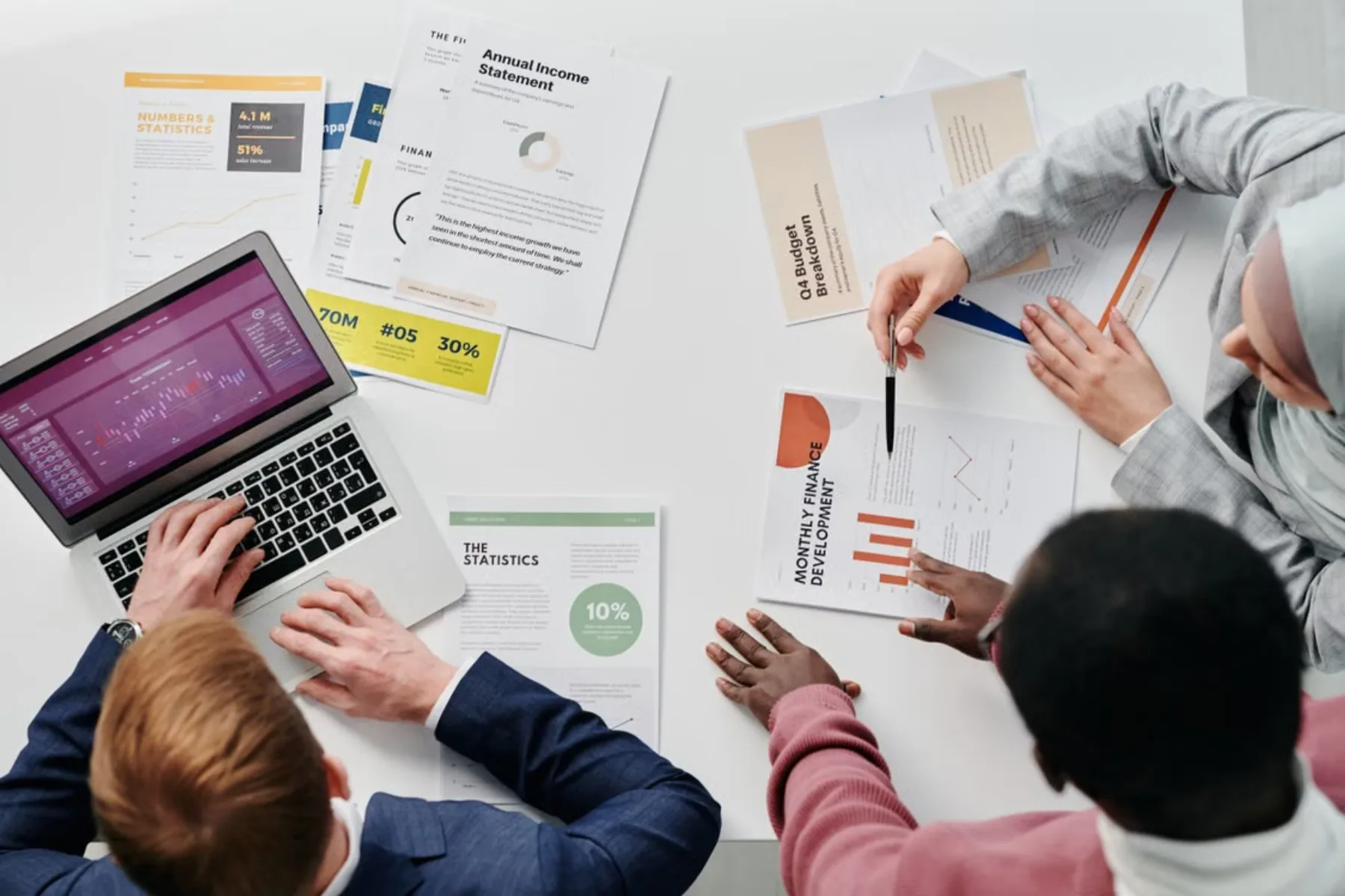 Financial planning documents and charts arranged around a laptop